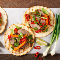 Mexican tacos with roasted  duck  meat, vegetables and green onion. Top view