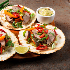 Mexican tacos with roasted  duck  meat, vegetables and green onion. Top view