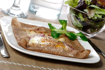 Breton crepe with egg in white plate