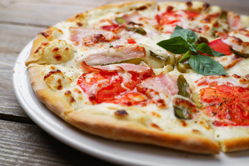 Italian hot pizza with bacon,tomatoes and gherkins, close up. Fast food, restaurant, pizzeria, food photo,pizza delivery concept