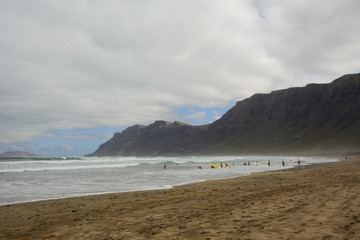Fototapeta na wymiar Caleta de Famara and surfers, Lanzarote, Canary Islands