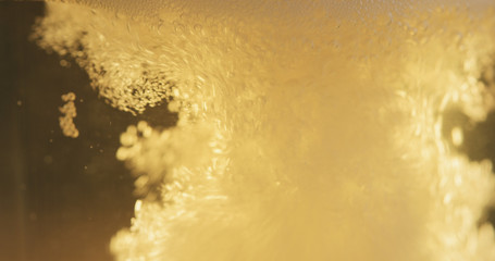 closeup of lager beer pouring in a glass