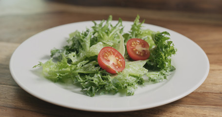 closeup adding tomatoes to caesar salad