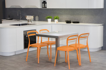 home house interior in kitchen white and grey with orange seat