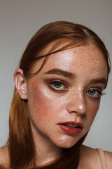 Obraz premium Portrait of a beautiful girl with long hair, makeup and freckles
