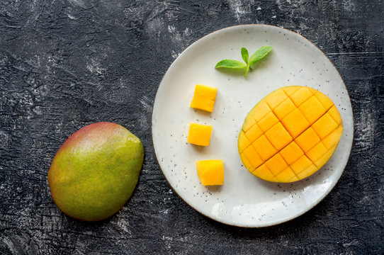 Sliced Mango Fruit On Plate. Top View. Dark Stone Background. 