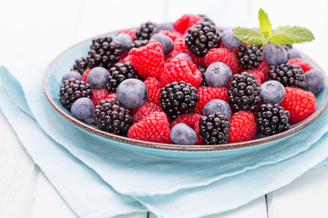 Fresh raspberries in a plate on a  vintage background.