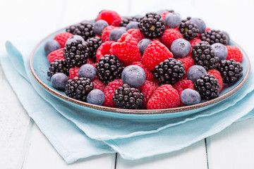 Fresh raspberries in a plate on a  vintage background.