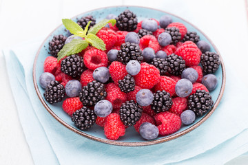 Fresh raspberries in a plate on a  vintage background.