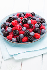 Fresh raspberries in a plate on a  vintage background.