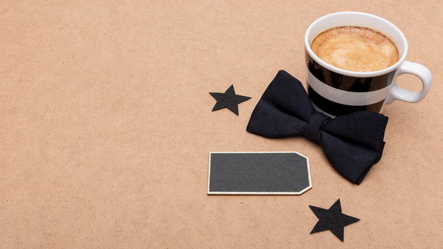 Happy Father's Day Background. Cup of coffee and black bow tie on brown background flat lay. Fathers day still life. - Powered by Adobe