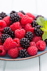Fresh raspberries in a plate on a  vintage background.