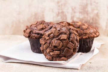 Homemade muffins with chocolate, vintage background.