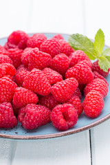 Fresh raspberries in a plate on a  vintage background.
