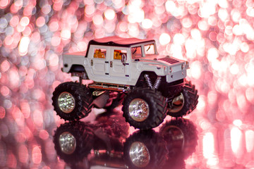 Bigfoot toy car color white, Car radio controller, background red BOKEH