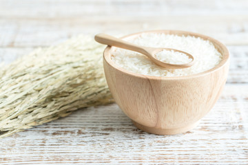 Jasmine rice in a wooden bowl on wooden