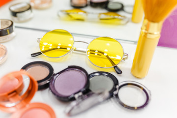 top view accessory of women tools for cosmetic and make-up and yellow trendy sun glasses