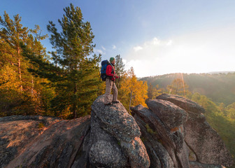 Backpacker on top of a rock fall at dawn. Wide angle aerial panorama