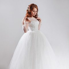 Fototapeta premium Lovely young woman bride in lavish wedding dress. Light background.