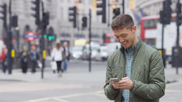 Handsome mixed race man using his phone outdoors in the city