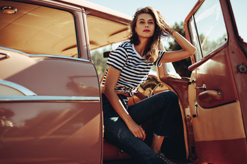 Beautiful young woman in a vintage car