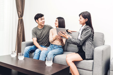 Obraz premium Real estate agent holding tablet and talk with young couple in a house for sale. business and real estate concept