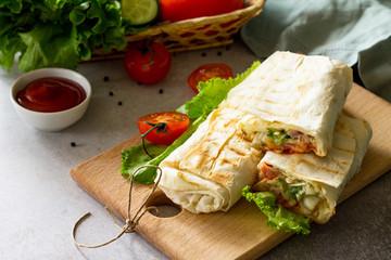Concept restaurant fast food. Copy space.Shaurma, shaurma doner, meat with vegetables in a bread cake, on a light stone background.
