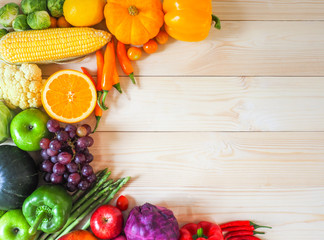 Colorful fresh fruits and vegetables on wood background, healthy eating concept.