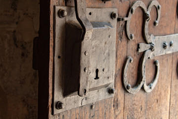 Big metal doorlock on a heavy wooden doorr in a castle