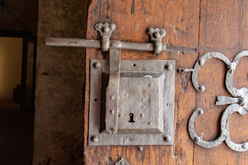 Big metal doorlock on a heavy wooden doorr in a castle