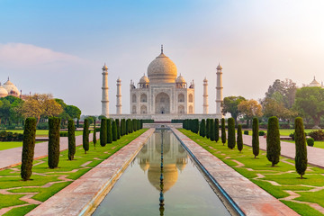 Fototapeta premium Widok z przodu Taj Mahal odbity w basenie refleksyjnym, mauzoleum z białego marmuru z kości słoniowej na południowym brzegu rzeki Jamuna w Agrze, Uttar Pradesh, Indie. Jeden z siedmiu cudów świata.