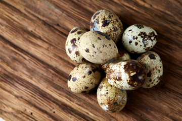 Group of three quail eggs on a wooden table, top view, close-up, selective focus, copy space.