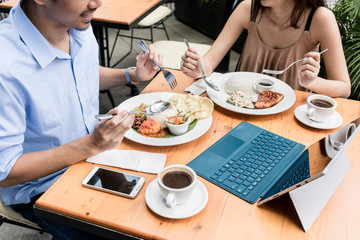 High angle view of the table of a young couple eating at restaurant with a tablet and a mobile phone on the table