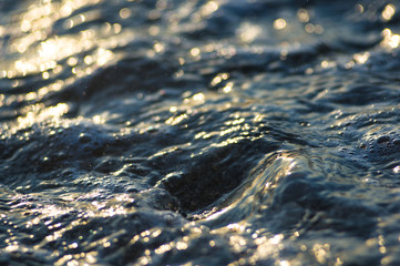 pebble stones on the sea beach, the rolling waves of the sea with foam