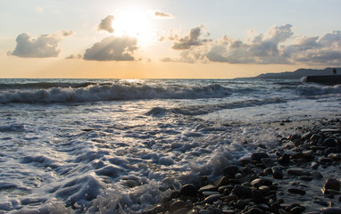 Fototapeta premium pebble stones on the sea beach, the rolling waves of the sea with foam