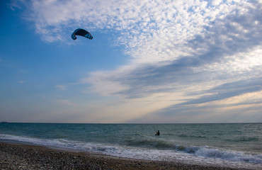 kitesurfer rides a kite-surf on waves of the sea