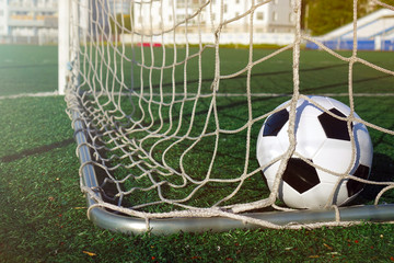 Football on a green field. The ball in the goal.