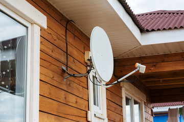 Satellite dish on the wall of the house.