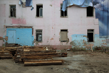 Part of the facade of an abandoned old stone house
