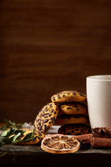 Traditional Christmas tea concept with a cup of hot tea, cookies and decorations on a wooden table, selective focus