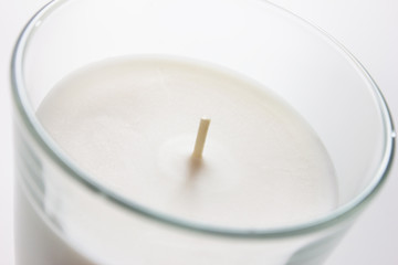 white candle with wick in glass
