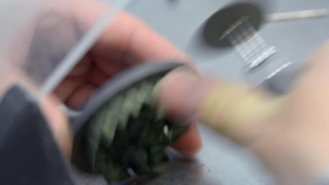Man cuts the small saw of the detail from the working disk disk for 3d metal printer. Dental crowns created in laser sintering machine. DMLS, SLM, SLS additive technology. 4.0 industrial revolution