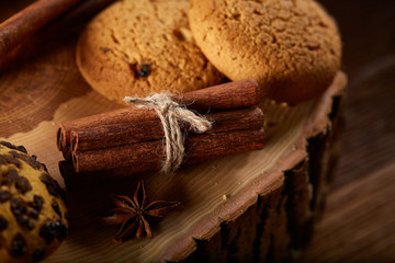 Sweet assortment of biscuits on a round wood log over rustic wooden background, close-up, selective focus.