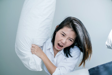 angry japanese woman mad at pillow  with emotion and violence anger management concept