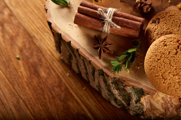 Fototapeta na wymiar Sweet assortment of biscuits on a round wood log over rustic wooden background, close-up, selective focus.