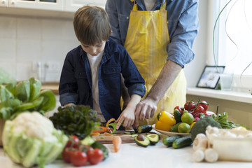 father and son cooking salad