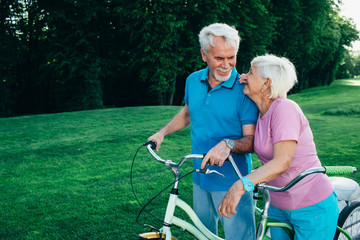 Fototapeta na wymiar senior couple going for a bicycle ride in the park