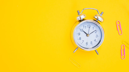 back to school or office styed scene with alarm clock and copy space on yellow background banner