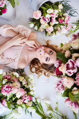 Beautiful young woman with make-up and curls. The girl's face is in flowers.