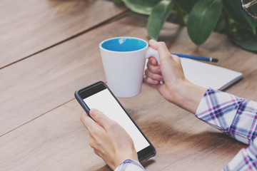 close up woman hand holding phone blank white screen display with vintage toned.
